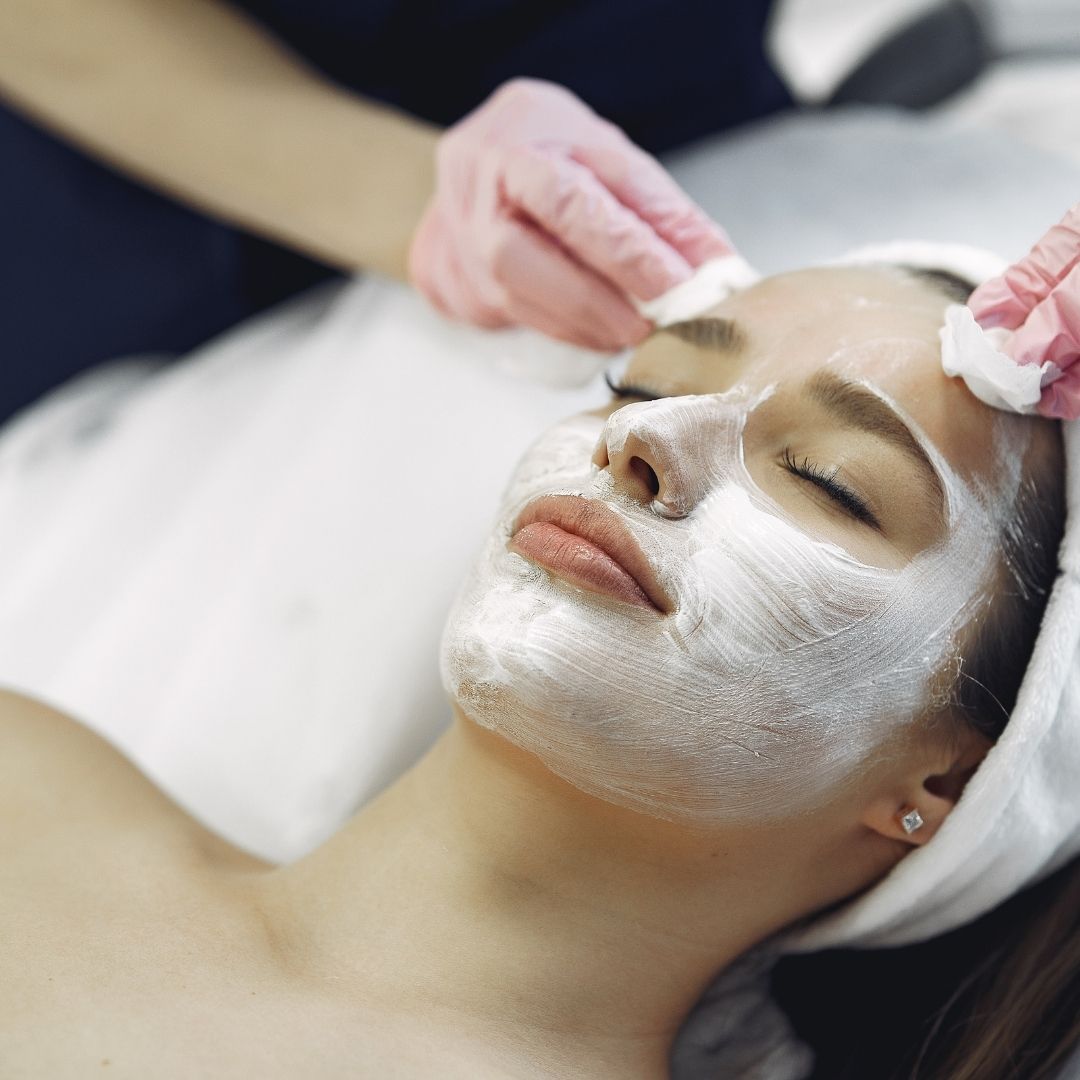 woman having a cream applied for her facial