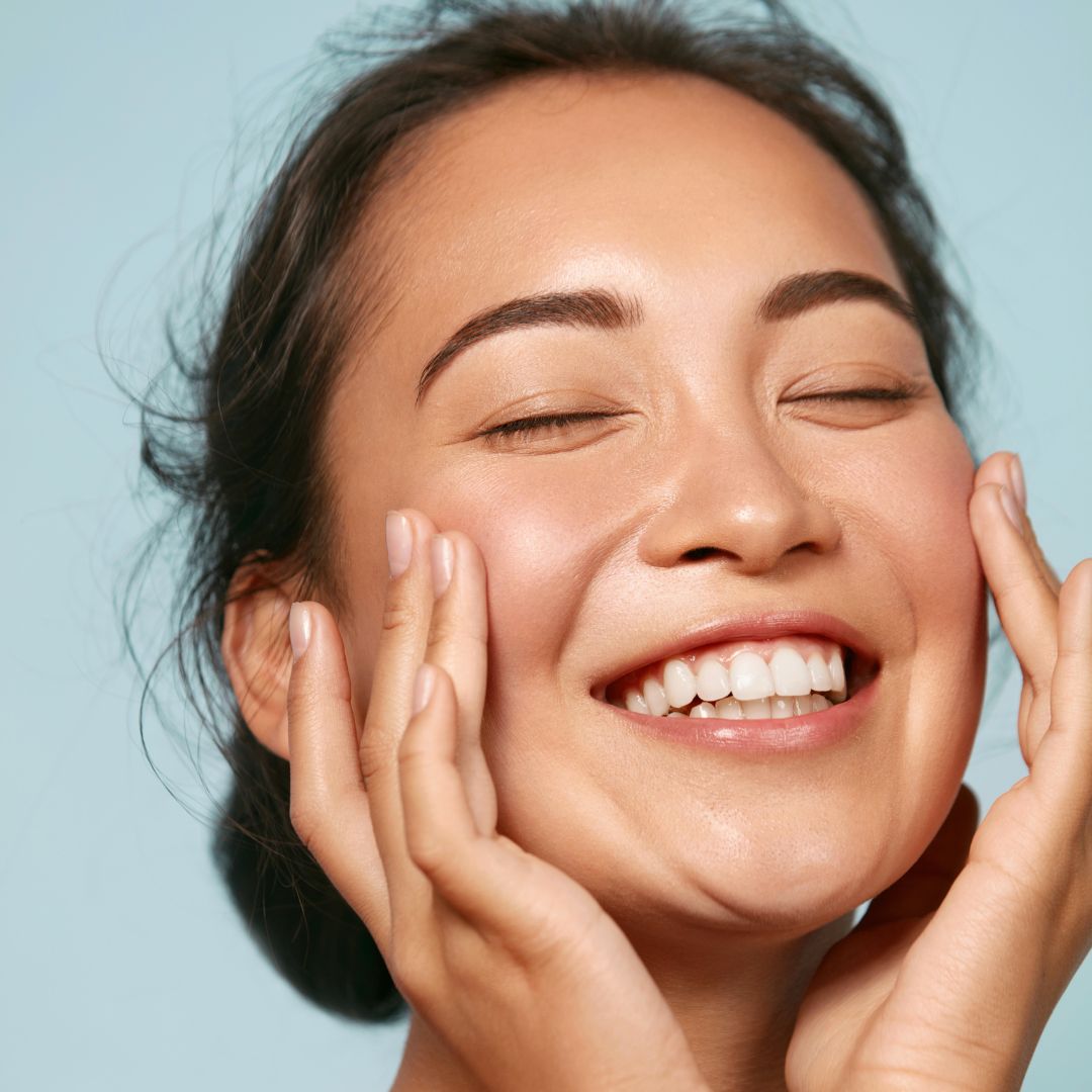 woman touching her cheeks and smiling