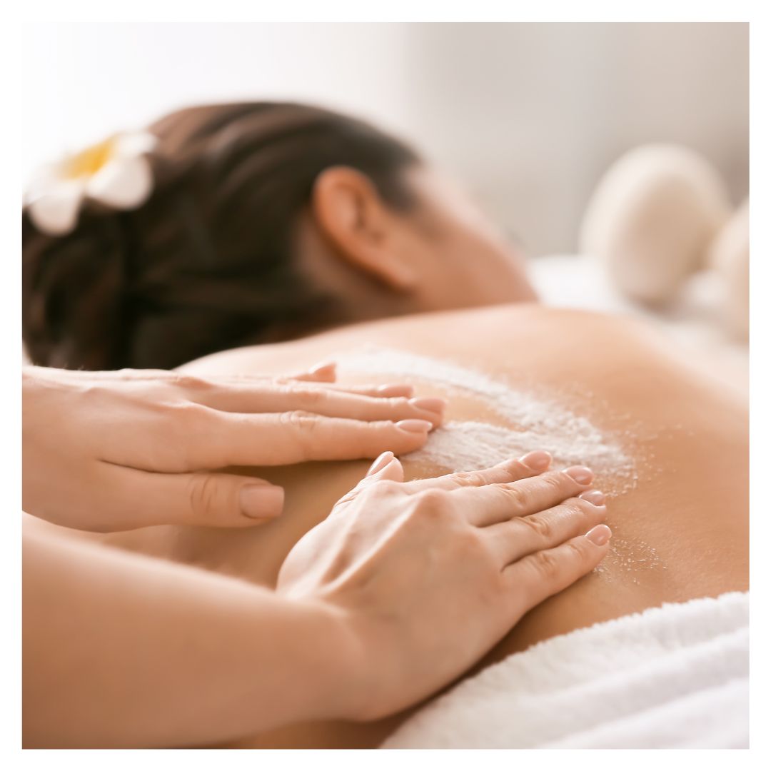 a woman receiving a body scrub on her back